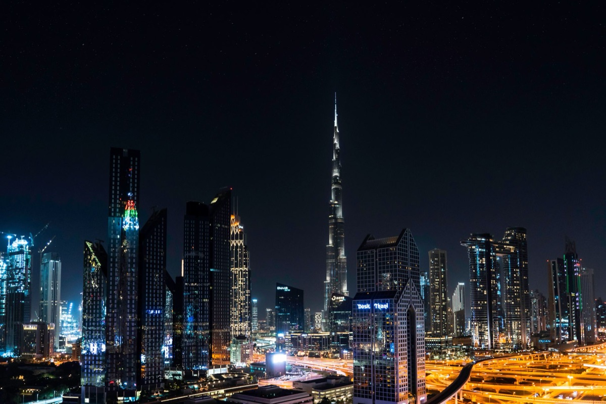 Dubai skyline at night with illuminated buildings and palm trees