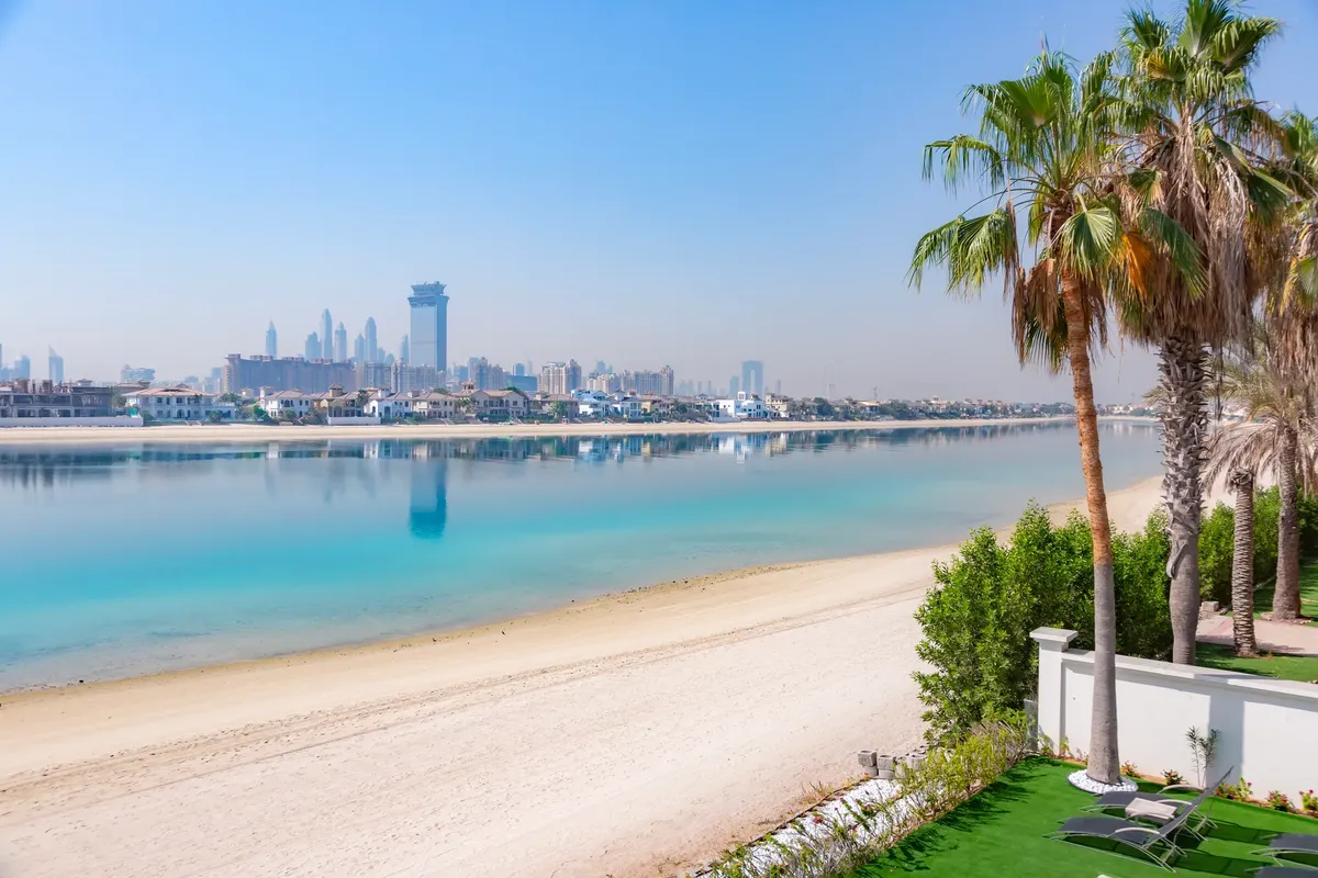 Stunning view of Dubai skyline from Palm Jumeirah featuring clear skies and turquoise waters.