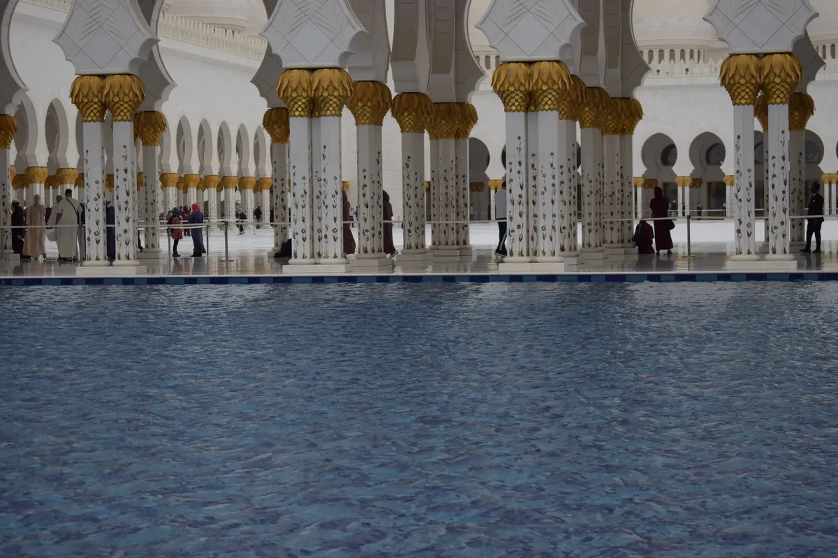 Serene view of the inner courtyard with reflections at Sheikh Zayed Grand Mosque, Abu Dhabi.