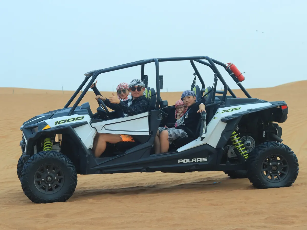 Family exploring Dubai's desert in a buggy, enjoying an adventurous ride together.