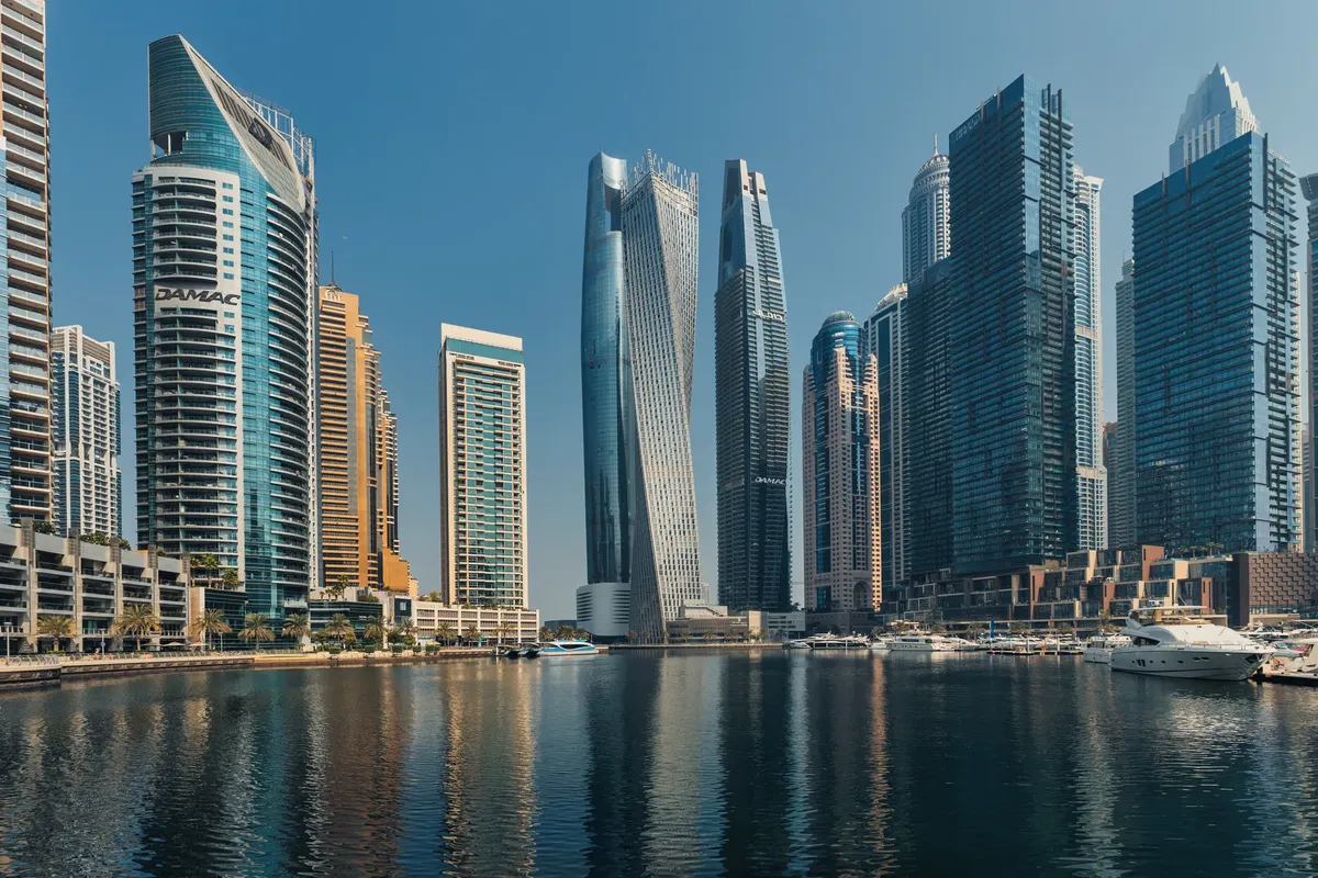 Explore a breathtaking view of the Dubai Marina skyline featuring iconic skyscrapers reflecting on tranquil waters.